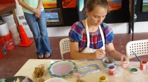 Girl painting handmade pottery